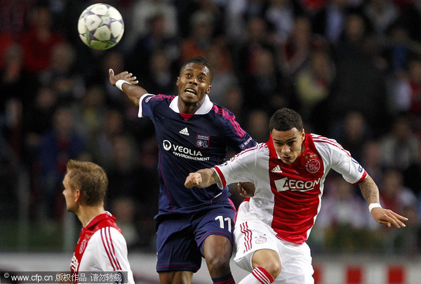 Gregory Van der Wiel of Ajax (R) battles for the ball with Michel Bastos of Olympique Lyon during their Champions League Group D soccer match at the Arena stadium in Asterdam, the Netherlands, Wednesday Sept. 14, 2011.