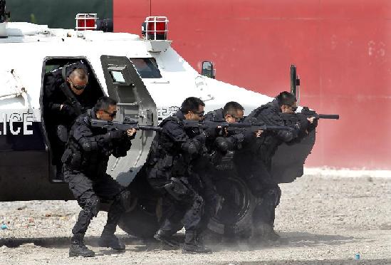 Special policemen open fire at terrorists during an anti-terror drill in Shanghai, Sept 14, 2011. The special police corps of Shanghai Public Security Bureau practiced the quick response ability to terrorist attacks and emergencies in the one-hour drill. [Photo/Xinhua]