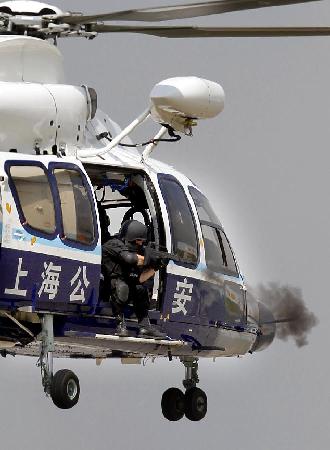 A special policeman shoot object from a helicopter during an anti-terror drill in Shanghai, Sept 14, 2011. [Photo/Xinhua]