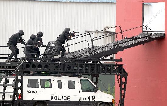 Special policemen launch strikes on a building where terrorists hide during an anti-terror drill in Shanghai, Sept 14, 2011. [Photo/Xinhua]