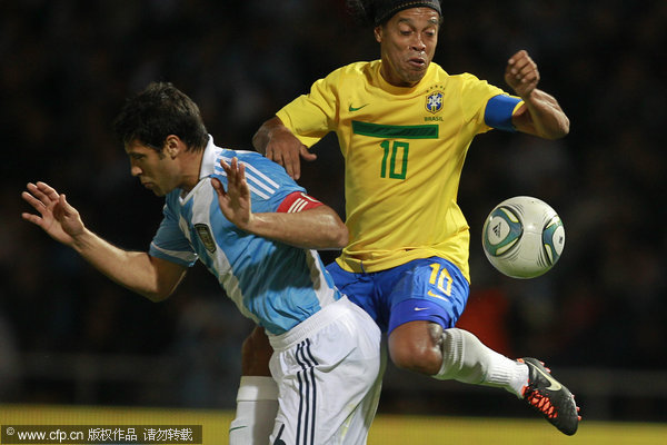 Brazil's Ronaldinho (R) and Argentina's Sebastian Dominguez(L) vie for the ball during a soccer friendly match in Cordoba, Argentina, Wednesday, Sept. 14, 2011.