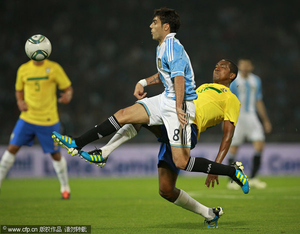 Argentina's Augusto Fernandez(top) and Brazil's Renato Abreu (R) compete for the ball during a soccer friendly match in Cordoba, Argentina, Wednesday, Sept. 14, 2011.