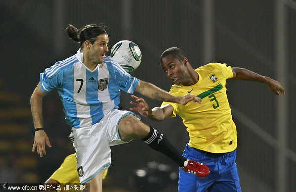 Argentina's Juan Manuel Martinez (left) and Brazil's Dede (right) vie for the ball during a friendly soccer match in Cordoba, Argentina, Wednesday, Sept. 14, 2011.