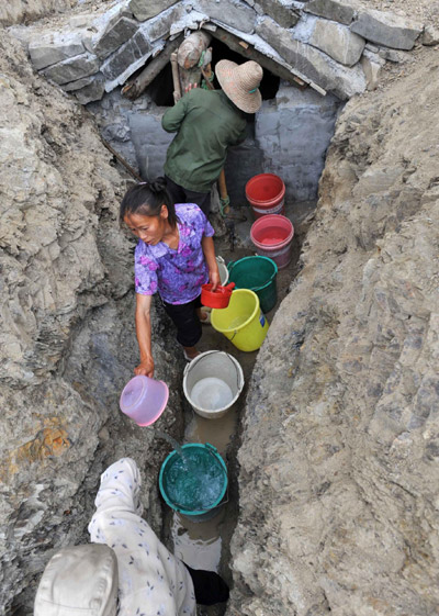 Villagers get water from an underground water tunnel in the Nahong neighborhood of Yakou Village, Longlin County in Guangxi Zhuang autonomous region on Sept 15, 2011.