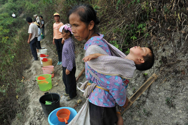 Villagers on their way to get water in the Nahong neighborhood of Yakou Village, Longlin County in Guangxi Zhuang autonomous region on Sept 15, 2011. 