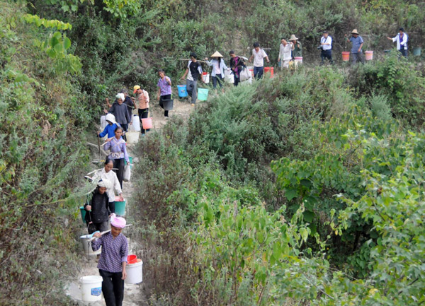 Villagers on their way to get water in the Nahong neighborhood of Yakou Village, Longlin County in Guangxi Zhuang autonomous region on Sept 15, 2011. 