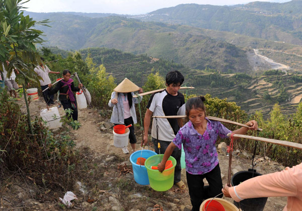 Villagers on their way to get water in the Nahong neighborhood of Yakou Village, Longlin County in Guangxi Zhuang autonomous region on Sept 15, 2011. 