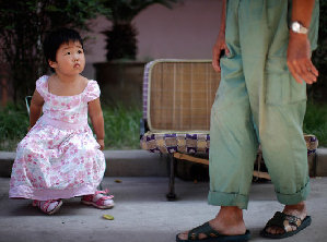 Zhao Jianyi, a 3-year-old who was diagnosed with high levels of lead in her blood, sits next to her grandfather at Kangqiao district near a Johnson Controls factory in Shanghai September 15, 2011. Zhao Jianyi registered 185 micro grams of lead per litre of blood, according to her doctors. [Agencies]
