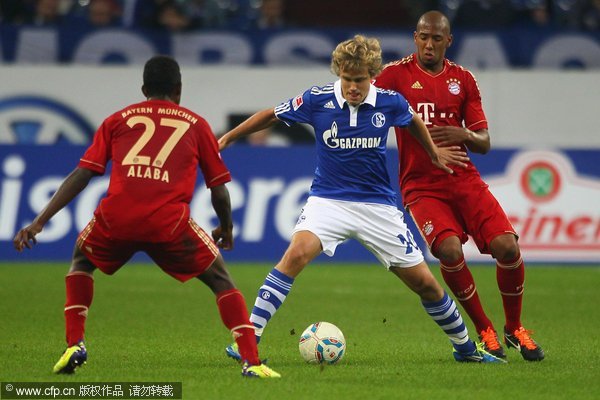 David Alaba of Bayern (L) and Jerome Boateng of Bayern (R) challenge Teemu Pukki (C) of Schalke during the Bundesliga match between FC Schalke 04 and FC Bayern Muenchen at Veltins Arena on September 18, 2011 in Gelsenkirchen, Germany.