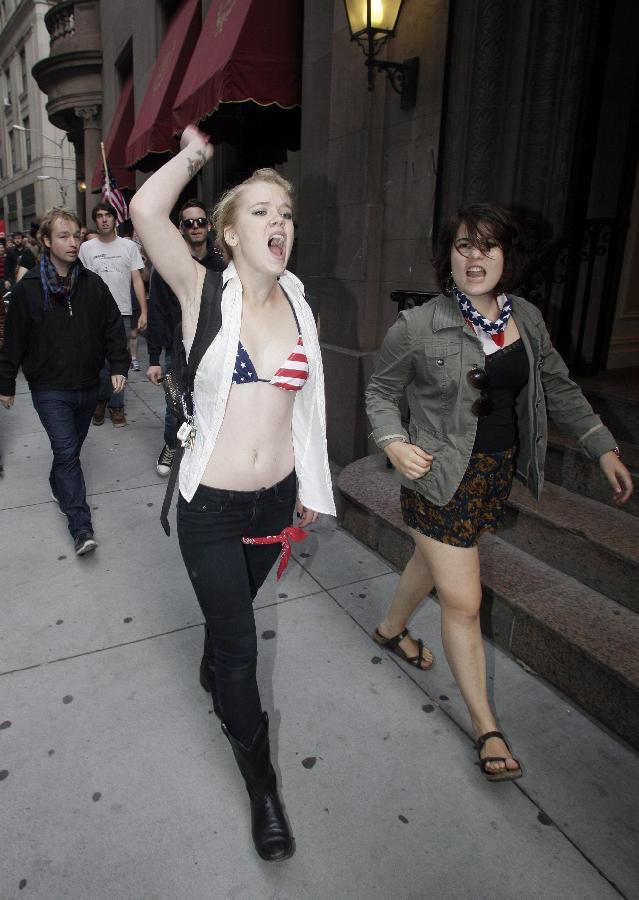 Protestors demonstrate near Wall Street against banks and corporations in New York September 17, 2011. According to their website, the mission of the leaderless resistance movement is to flood thousands of people into lower Manhattan, set up beds, kitchens, peaceful barricades and occupy Wall Street for a few months in order to persuade President Barack Obama to establish a commission to end 'the influence money has over representatives in Washington.' [Xinhua/AFP Photo] 