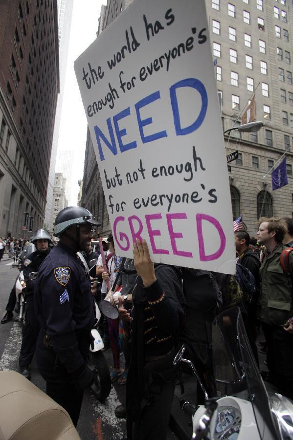 Demonstrators gather in front of a police barricade to call for the occupation of Wall Street, Sept. 17, 2011, in New York. According to their website, the mission of the leaderless resistance movement is to flood thousands of people into lower Manhattan, set up beds, kitchens, peaceful barricades and occupy Wall Street for a few months in order to persuade President Barack Obama to establish a commission to end 'the influence money has over representatives in Washington.' [Xinhua/AFP Photo]