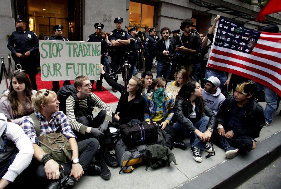 Demonstrators gather in front of a police barricade to call for the occupation of Wall Street, Sept. 17, 2011, in New York. According to their website, the mission of the leaderless resistance movement is to flood thousands of people into lower Manhattan, set up beds, kitchens, peaceful barricades and occupy Wall Street for a few months in order to persuade President Barack Obama to establish a commission to end 'the influence money has over representatives in Washington.' [Xinhua/AFP Photo] 