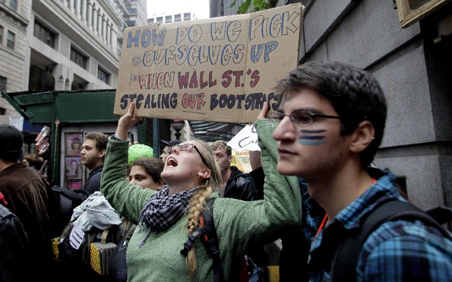 Protestors demonstrate near Wall Street against banks and corporations in New York September 17, 2011. According to their website, the mission of the leaderless resistance movement is to flood thousands of people into lower Manhattan, set up beds, kitchens, peaceful barricades and occupy Wall Street for a few months in order to persuade President Barack Obama to establish a commission to end 'the influence money has over representatives in Washington.' [Xinhua/AFP Photo]