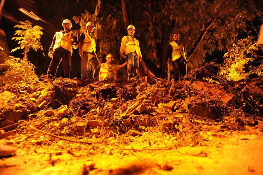 British Embassy staff look on after the embassy's compound wall collapsed reportedly killing three pedestrians following an earthquake in Katmandu, Nepal, Sunday, Sept. 18, 2011. A strong earthquake shook northeastern India and Nepal on Sunday night, killing at least 16 people, damaging buildings and sending lawmakers in Nepal's capital running into the streets. [Xinhua/AFP Photo]