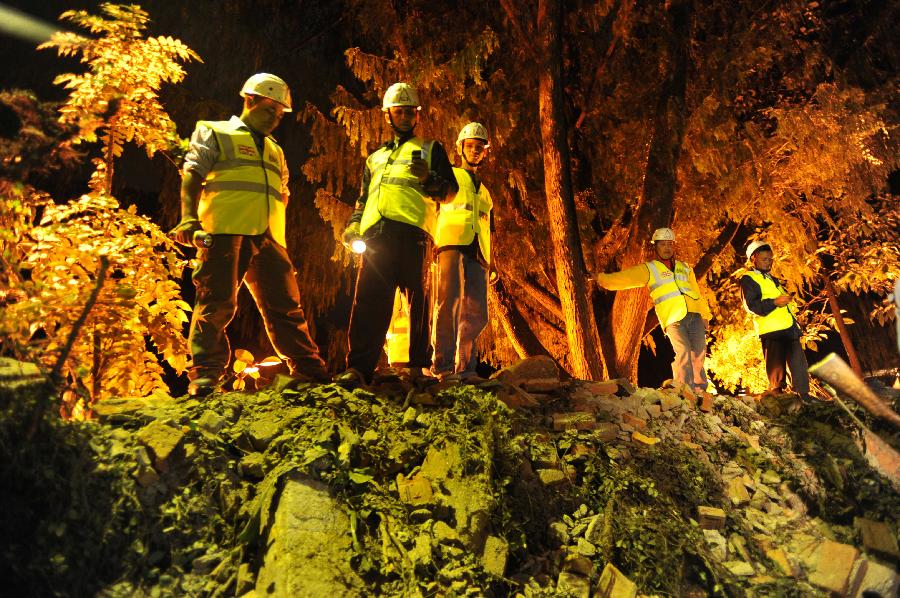 British Embassy staff look on after the embassy's compound wall collapsed reportedly killing three pedestrians following an earthquake in Katmandu, Nepal, Sunday, Sept. 18, 2011. A strong earthquake shook northeastern India and Nepal on Sunday night, killing at least 16 people, damaging buildings and sending lawmakers in Nepal's capital running into the streets. [Xinhua/AFP Photo]