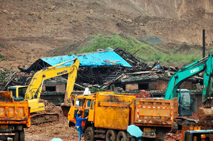 Excavators work to clear a landslide yesterday in Baqiao District of Xi'an City in northwest China's Shaanxi Province. Rain triggered a slide that hit two factories. Ten people were killed, five injured and 22 were still missing yesterday. 