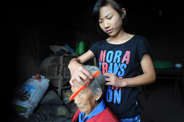 Li combs her grandmother's hair in Ganshui town of Qijiang county, Chongqing municipality on Sept 18, 2011. [Photo/Xinhua]