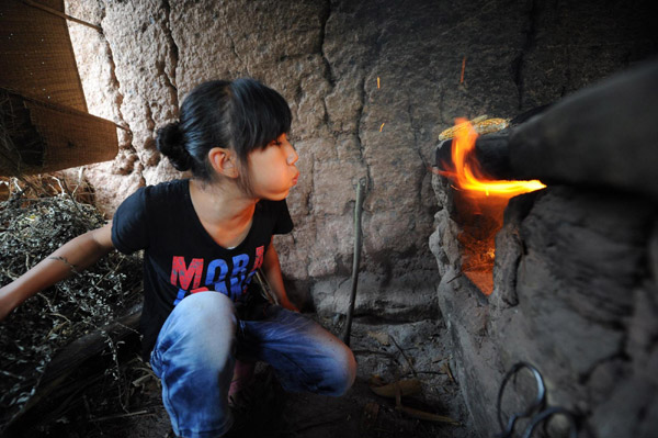 Li prepares dinner in her shack in Ganshui town of Qijiang county, Chongqing mMunicipality on Sept 18, 2011. [Photo/Xinhua] 