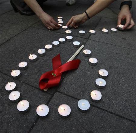 Activists distribute red ribbons and light up candles as they commemorate victims of the Human Immunodeficiency Virus, or HIV, during a flashmob in St.Petersburg May 16, 2010. [Reuters]