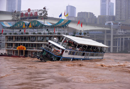 A ferry restaurant sinks off the Yu'ao Bridge in Chongqing's downtown when flooding hit the southwestern city yesterday. Ten people fell into the river during the afternoon accident. Eight were rescued but two are still missing. 