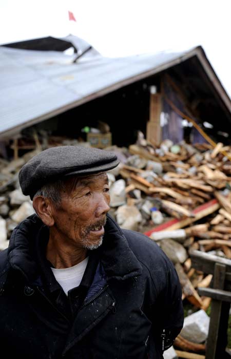 A Tibetan old man stands in front of his damaged house in Yadong county in the Tibet autonomous region on Sept 19, 2011 