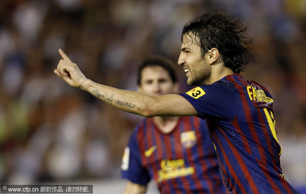 Barcelona's Cesc Fabregas celebrates after scoring against Valencia during their La liga soccer match at Mestalla stadium in Valencia on wednesday, Sept. 21, 2011.