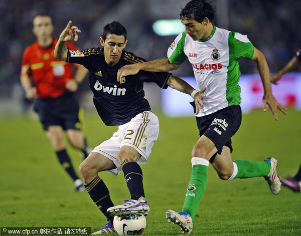 Real Madrid's Angel di Maria (left) duels for the ball with Racing Santander's Francisco Perez during their La Liga soccer match at the Sardinero Stadium in Santanderon Wednesday Sept. 21, 2011.