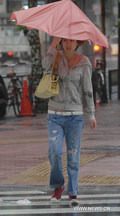 A pedestrian walks in strong wind in Tokyo, Japan, Sept. 21, 2011. Typhoon Roke landed on Japan's largest island of Honshu Wednesday afternoon, after it had already killed at least six people, authorities said. (Xinhua/kenichiro Seki) (srb) 