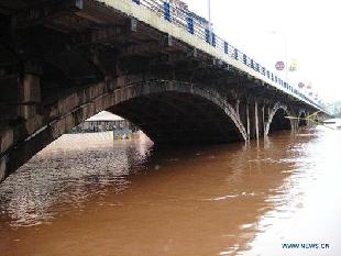 Rising waters submerge the piers of the Qujiang Bridge in Quxian County, southwest China's Sichuan Province, Sept. 19, 2011. [Xinhua] 