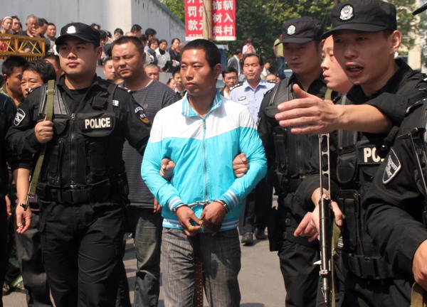 Police take Zhang Xiaobo in for questioning on Wednesday over the killing of TV reporter Li Xiang in Luoyang, Henan province. Zhang is one of two men suspected of stabbing the journalist to death in a robbery on Sunday. 
