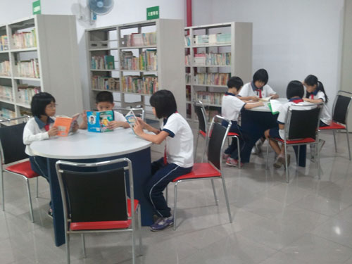 Children read books at a community culture and sports center in Xiaolan town, Zhongshan city, south China's Guangdong province, on Thursday, September 22, 2011. [Photo: CRIENGLISH.com/Zhang Xu] 