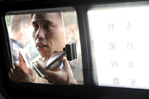 A man waits for his turn to buy a train ticket at the Taiyuan Railway Station in the capital city of North China's Shanxi province on Wednesday.