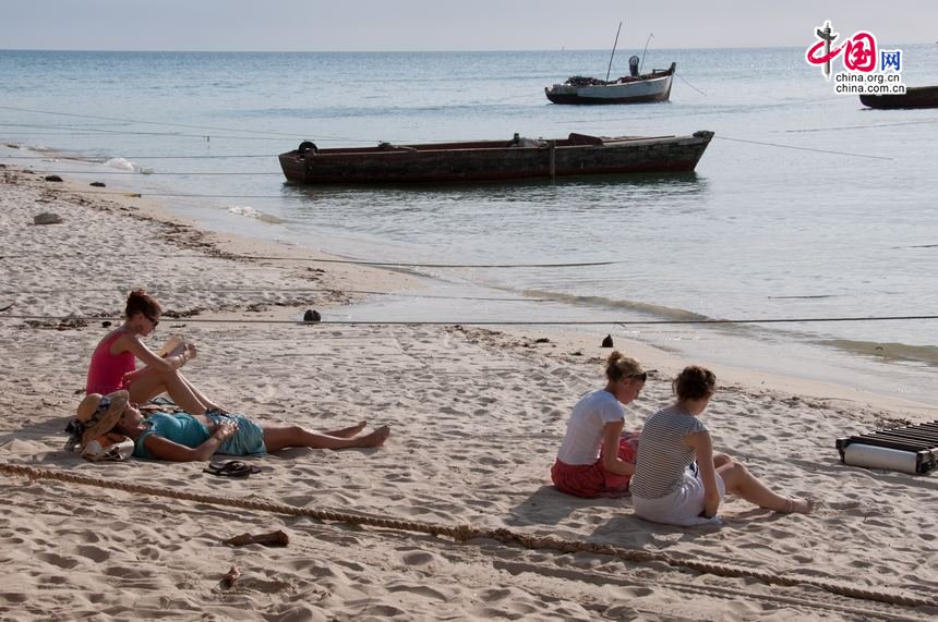 Tourists from the West enjoy a sunbath at the beach of Zanzibar. [Maverick Chen / China.org.cn]
