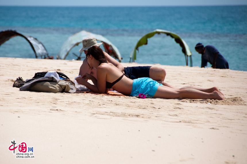 Tourists from the West enjoy a sunbath at the beach of Zanzibar. [Maverick Chen / China.org.cn]