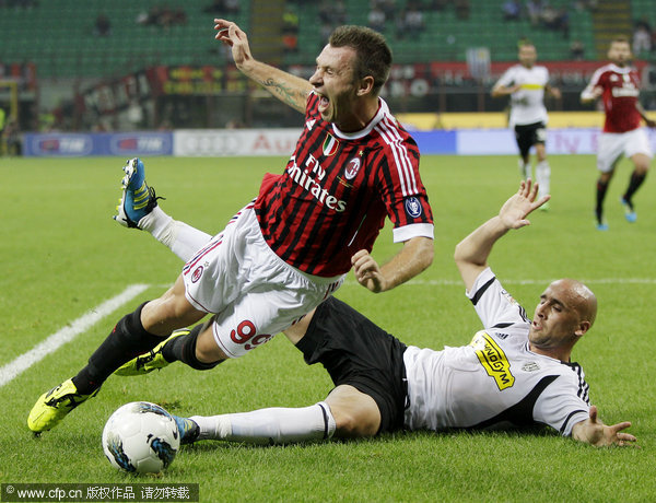 AC Milan forward Antonio Cassano (left) is tackled by Cesena defender Guillermo Rodriguez during the Serie A soccer match between AC Milan and Cesena at the San Siro stadium in Milan on Saturday, Sept. 24, 2011.