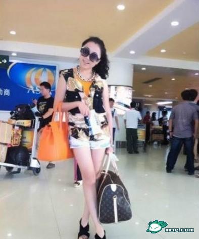 You Yixi holds two designer bags believed to be worth at least 100,000 yuan.