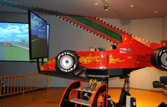 Visitors experience the simulated driving of racing car at the Beijing Auto Museum in Beijing, capital of China, Sept. 23, 2011. The Beijing Auto Museum opened to public on Friday. It exhibits abundant auto-related documents and over 80 cars with historical significance. [Photo:Xinhua]