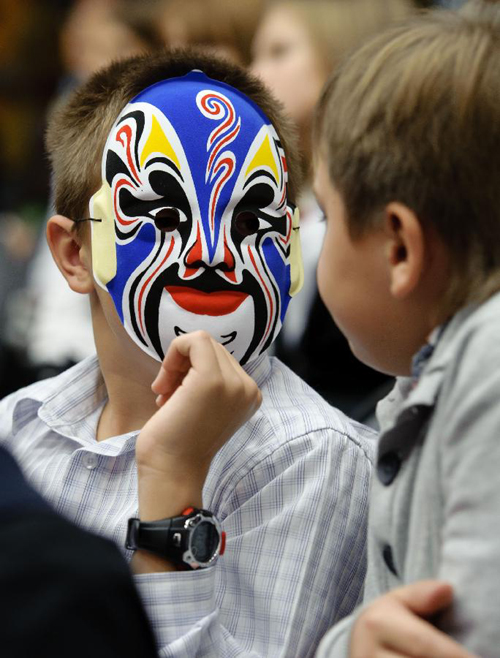 A student with a Chinese traditional mask talks to others during a Chinese language culture festival in Moscow, Russia, Sept. 24, 2011. A Chinese language culture festival was held in the 1948 School in Moscow, attracting Chinese middle school students and pupils living in Moscow and Russian students who loved Chinese culture to attend. 