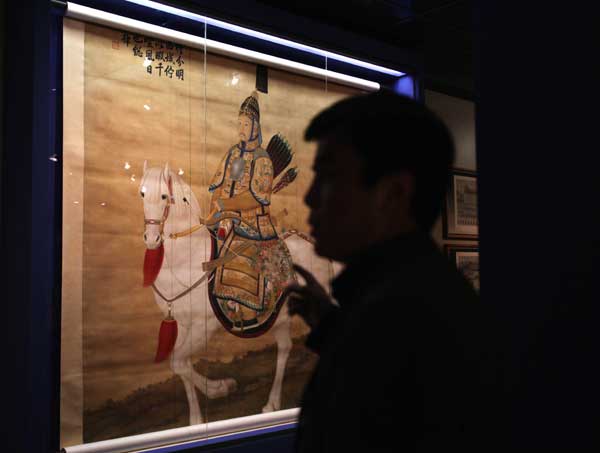 A visitor watches a portrait of Emperor Qianlong in the Louvre Museum in Paris, capital of France, on Sept. 26, 2011. About 130 artifacts from the Forbidden City, China's ancient imperial palace museum, started to greet the French public in the Louvre Museum on Monday in an exhibition that will run until Jan. 9, 2012.