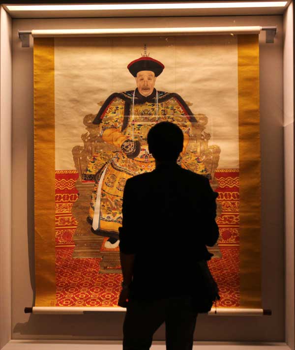 A visitor watches a portrait of Emperor Kangxi in the Louvre Museum in Paris, capital of France, on Sept. 26, 2011. About 130 artifacts from the Forbidden City, China's ancient imperial palace museum, started to greet the French public in the Louvre Museum on Monday in an exhibition that will run until Jan. 9, 2012.