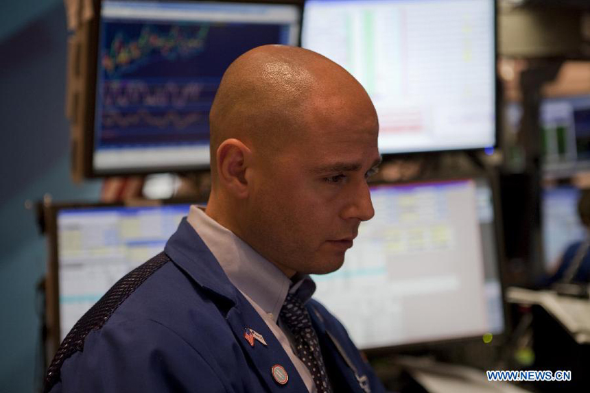 A trader works at the New York Stock Exchange in New York, the United States, on Sept. 27, 2011. The U.S. stocks significantly cut early gains but still finished higher for the third straight session on Tuesday as investors were expecting that European leaders were coming closer to a plan which can help Greece avert a default on its debt.