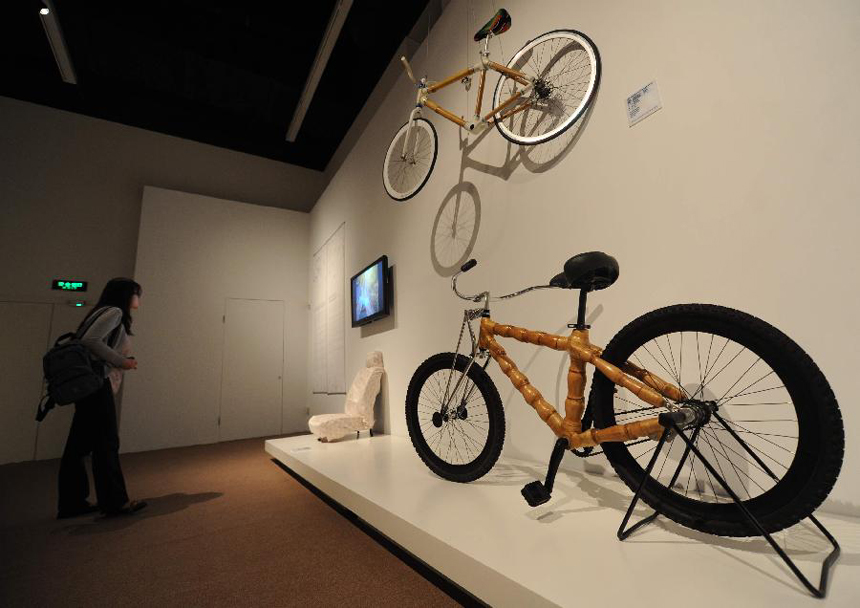 A visitor looks at the exhibits on the sub-theme exhibition 'Rethinking Bamboo' of the Beijing International Design Triennial in Beijing, capital of China, Sept. 27, 2011. The exhibition, which was opened here on Tuesday, presents spectators with over 2,000 design works from some 500 designers of more than 40 countries and regions.