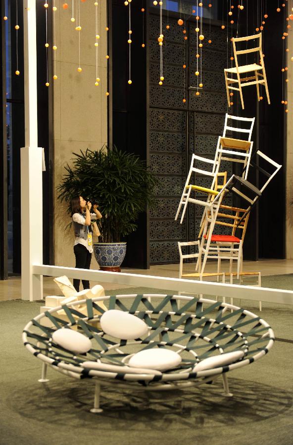 A visitor looks at the exhibits on the sub-theme exhibition 'Creative Junctions' of the Beijing International Design Triennial in Beijing, capital of China, Sept. 27, 2011. The exhibition, which was opened here on Tuesday, presents spectators with over 2,000 design works from some 500 designers of more than 40 countries and regions.