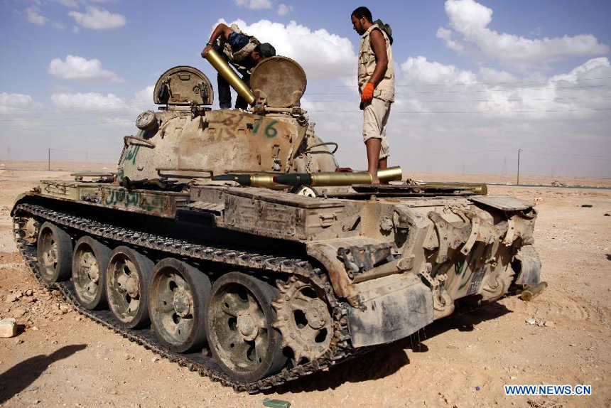 Fighters of the force of the Interim National Council of the Libyan (NTC) install shells to a tank outside Bani Walid, Libya, Sept. 27, 2011. Bani Walid is still occupied by fighters loyal to Muammar Gaddafi.