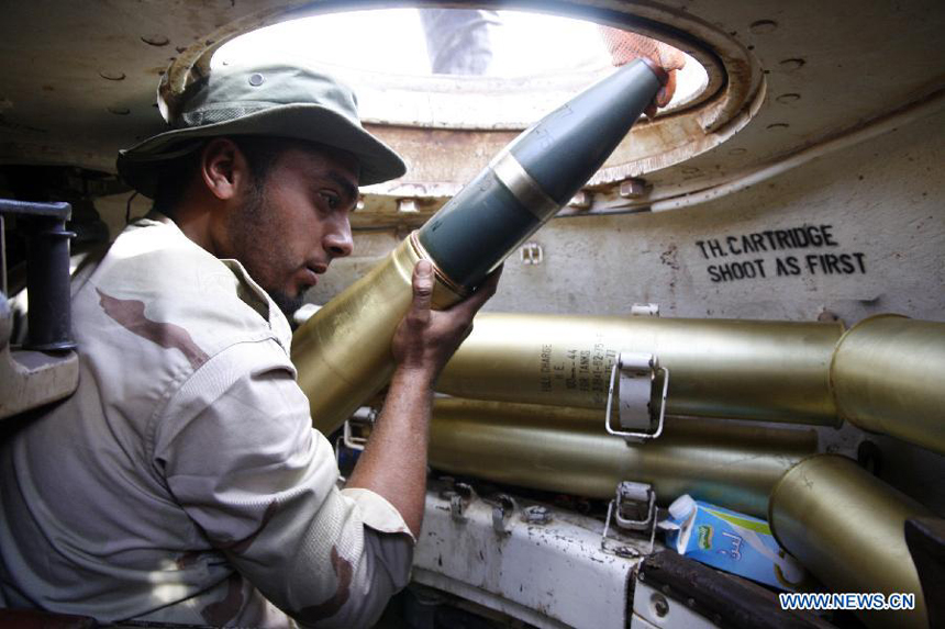 A fighter of the force of the Interim National Council of the Libyan (NTC) installs shells inside a tank outside Bani Walid, Libya, Sept. 27, 2011. Bani Walid is still occupied by fighters loyal to Muammar Gaddafi. 