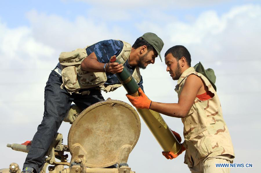 Fighters of the force of the Interim National Council of the Libyan (NTC) install shells to a tank outside Bani Walid, Libya, Sept. 27, 2011. Bani Walid is still occupied by fighters loyal to Muammar Gaddafi.