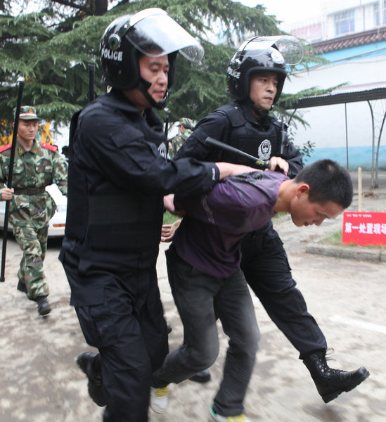 Prison guards and armed police officers apprehend a prisoner’s family member who was preparing to aid in the prison break during a drill at Yuxi prison in Luoyang, Central China's Henan province on Sept 27, 2011. Photo/CFP]