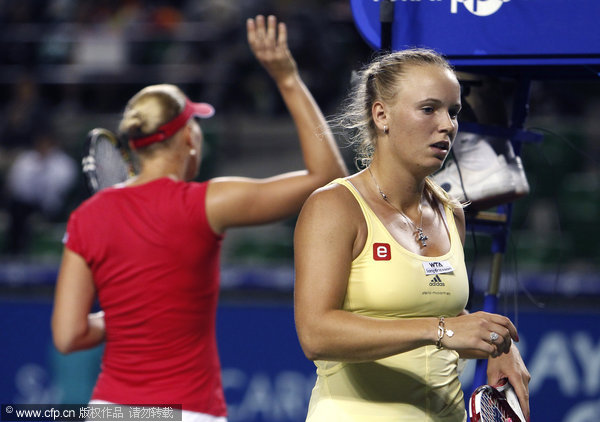 Caroline Wozniacki (right) walks to a chair after her loss to Kaia Kanepi (left) at the Japan Pan Pacific Open Tennis Tournament in Tokyo on Wednesday, sept. 28, 2011. 