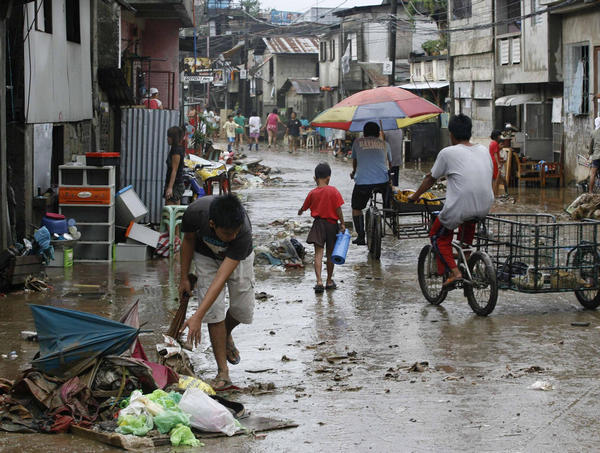 Residents clean up after flooding in Marikina City, Metro Manila Sept 28, 2011. The Philippines began on Wednesday the clean-up of flooded areas and assessments of damage, including to the key rice crop, a day after Typhoon Nesat left behind at least 31 dead. [China Daily] 