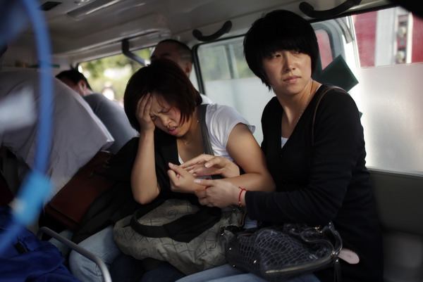 Women who had been riding the Shanghai subway on Tuesday afternoon await treatment in ambulances after one subway train rear-ended another, which had stalled on Line 10. [Photo/China Daily via Reuters]